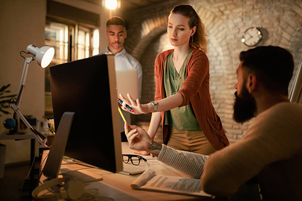 young-businesswoman-her-colleagues-brainstorming-while-using-desktop-pc-office